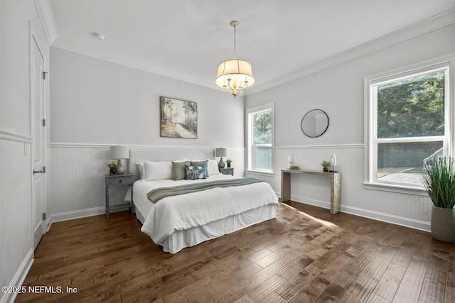 bedroom with ornamental molding, dark wood-type flooring, and an inviting chandelier