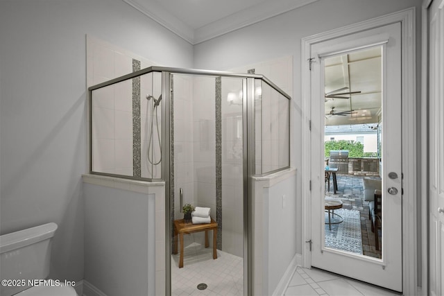 bathroom featuring tile patterned floors, crown molding, ceiling fan, toilet, and a shower with shower door