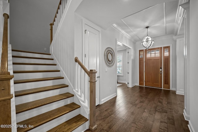 entrance foyer with an inviting chandelier, dark wood-type flooring, and ornamental molding