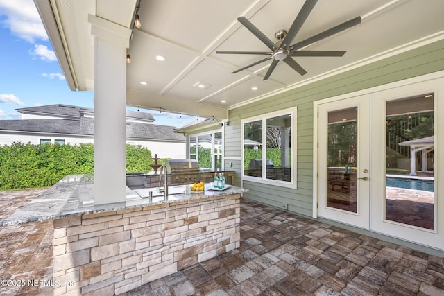 view of patio featuring exterior bar, french doors, area for grilling, and ceiling fan