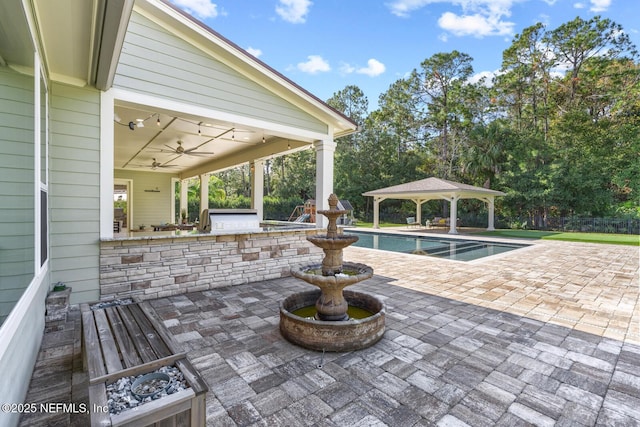 view of patio / terrace with a gazebo, an outdoor kitchen, and ceiling fan