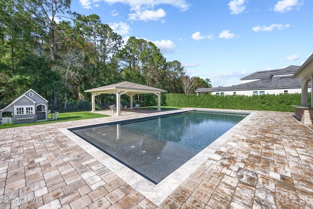 view of pool with a gazebo, an outdoor structure, a patio area, and a lawn