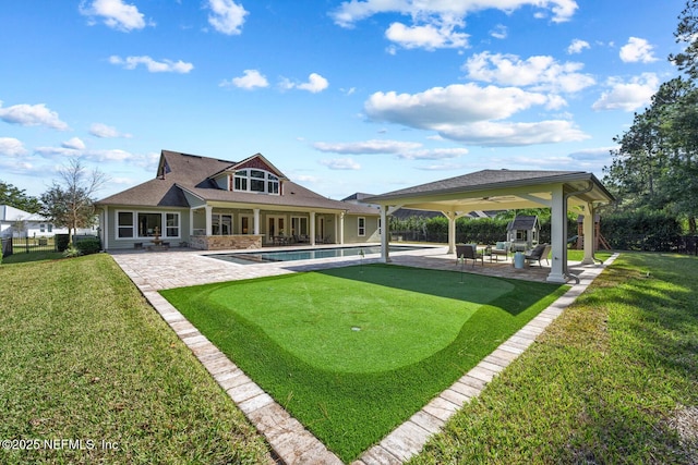 back of house featuring a lawn, ceiling fan, and a patio area