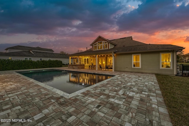 pool at dusk with a patio