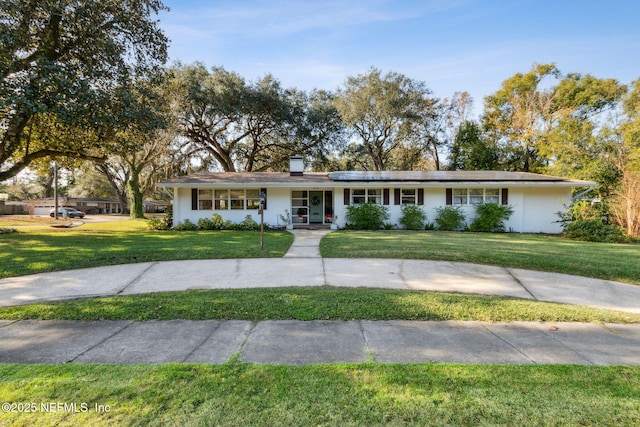 ranch-style house featuring a front yard, solar panels, and a porch