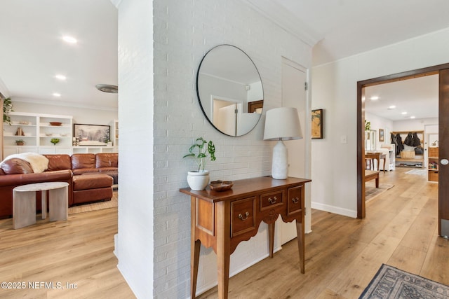 hall with crown molding and light hardwood / wood-style flooring