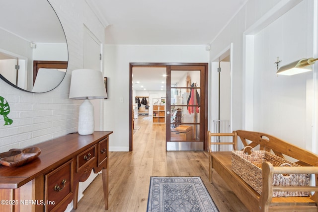 corridor featuring crown molding and light wood-type flooring