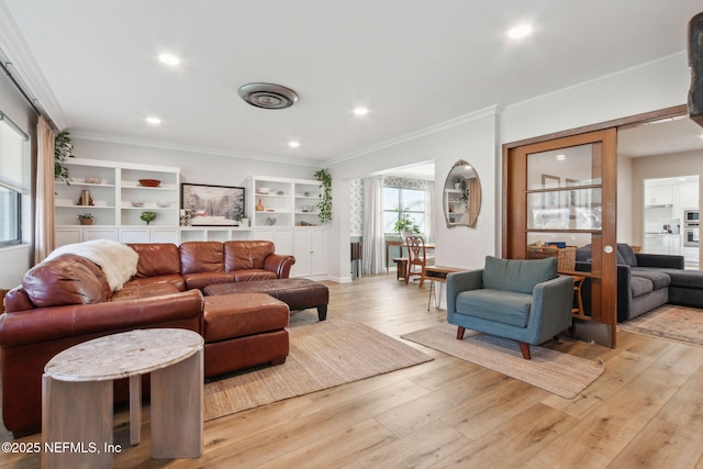 living room with crown molding and light hardwood / wood-style floors