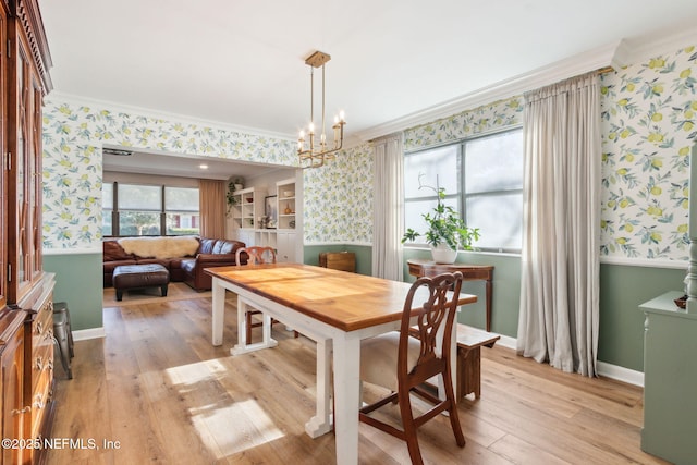 dining room featuring crown molding, light hardwood / wood-style flooring, and a chandelier