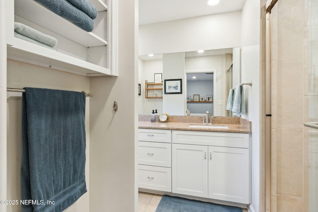 bathroom with vanity, tile patterned floors, and a shower with door