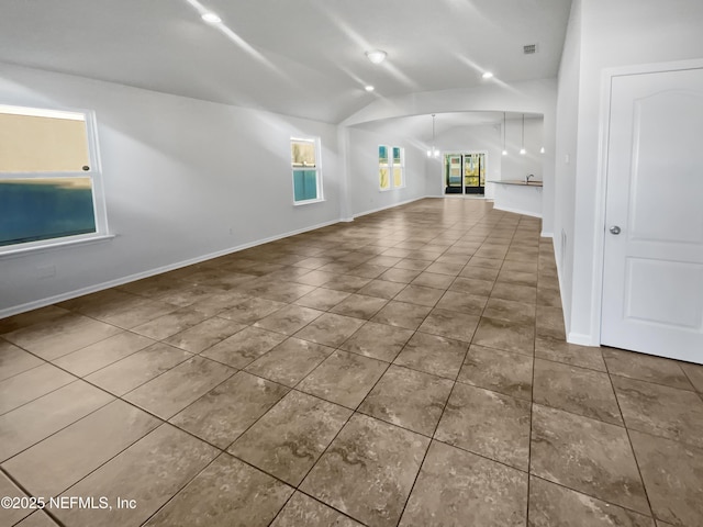 unfurnished living room featuring tile patterned floors and vaulted ceiling