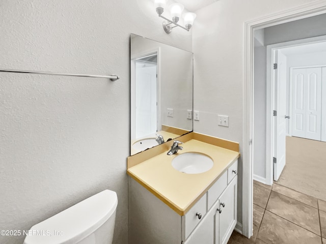 bathroom featuring tile patterned floors, vanity, and toilet