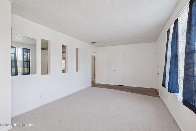 carpeted spare room featuring a textured ceiling