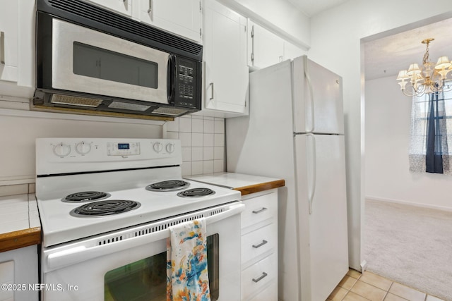 kitchen with light carpet, decorative backsplash, white appliances, an inviting chandelier, and white cabinets