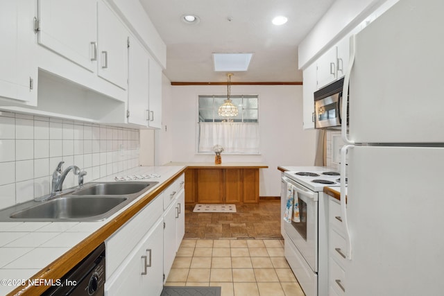 kitchen with pendant lighting, white appliances, sink, tile counters, and white cabinetry