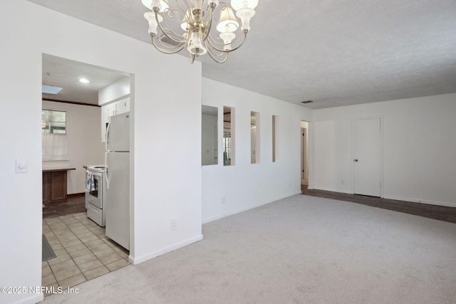 carpeted empty room featuring a textured ceiling and an inviting chandelier