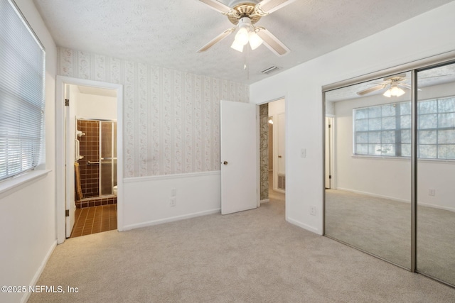 unfurnished bedroom with light carpet, a closet, and ceiling fan