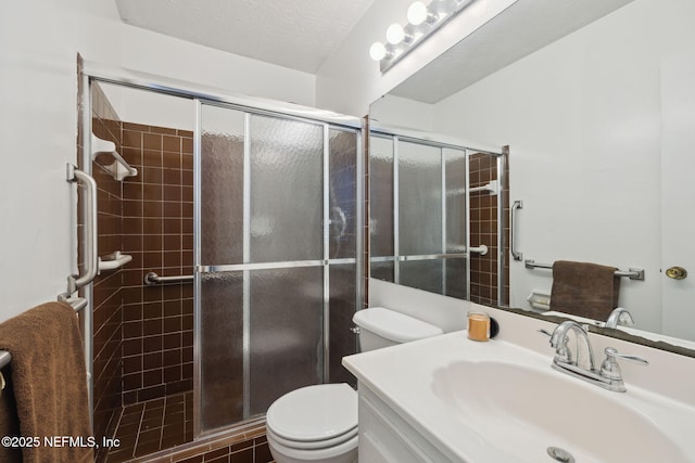 bathroom featuring a textured ceiling, vanity, toilet, and walk in shower