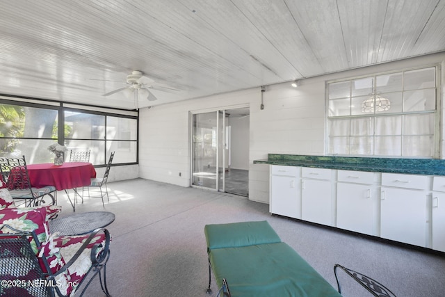 sunroom featuring ceiling fan and wooden ceiling