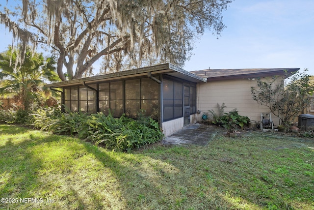 view of property exterior with a sunroom and a lawn