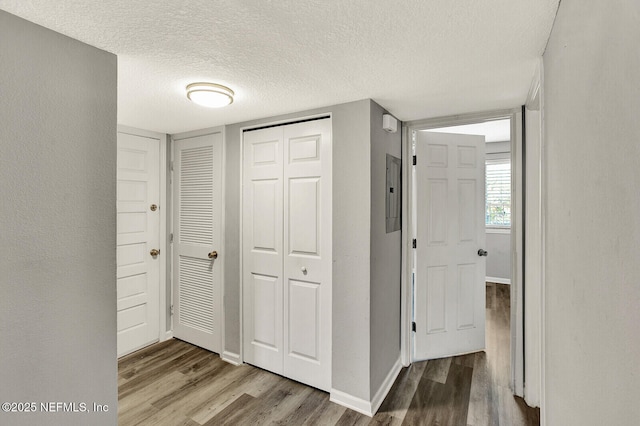 hallway with hardwood / wood-style floors and a textured ceiling