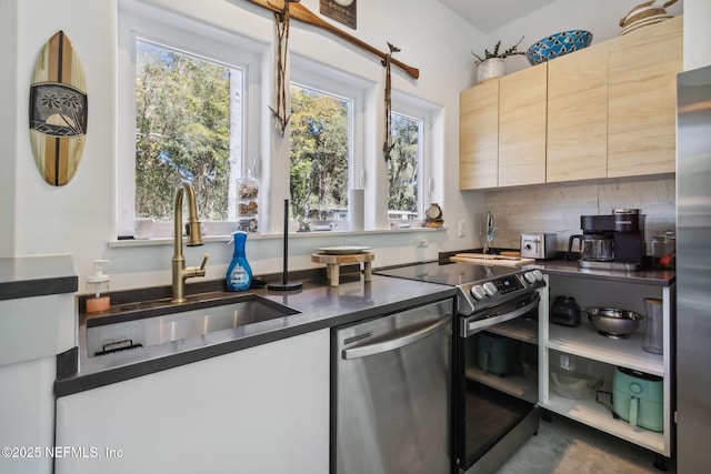 kitchen with tasteful backsplash, sink, and appliances with stainless steel finishes