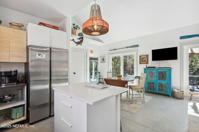 kitchen featuring pendant lighting, white cabinetry, high end fridge, and lofted ceiling