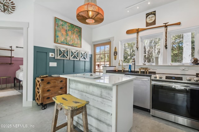 kitchen with a wealth of natural light, sink, a kitchen island, and appliances with stainless steel finishes