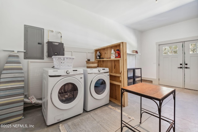 clothes washing area featuring electric panel and washer and dryer