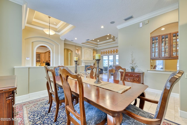 dining area with a raised ceiling, light tile patterned flooring, and crown molding