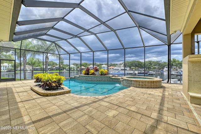 view of swimming pool featuring glass enclosure, a patio area, an in ground hot tub, and a water view