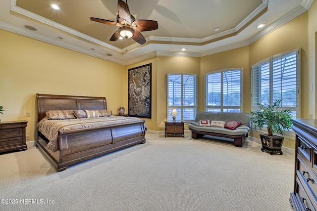 carpeted bedroom featuring a raised ceiling, ceiling fan, ornamental molding, and multiple windows