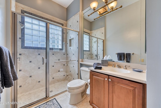 bathroom featuring toilet, tile patterned floors, vanity, and a shower with shower door