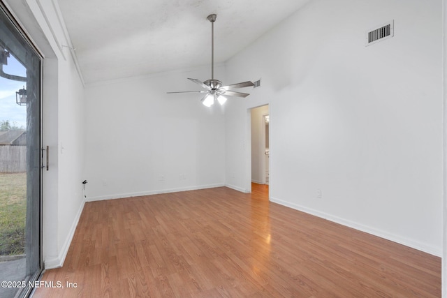 empty room featuring ceiling fan, light hardwood / wood-style flooring, high vaulted ceiling, and plenty of natural light