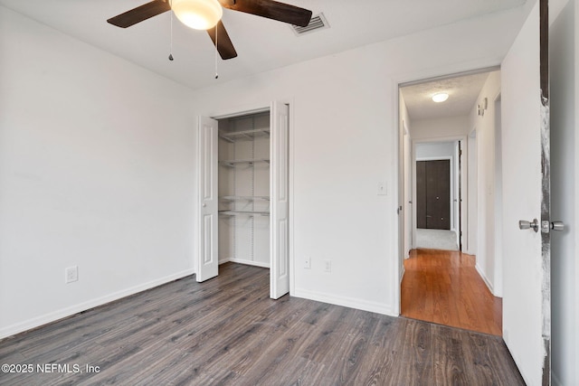 unfurnished bedroom featuring dark hardwood / wood-style flooring, a closet, and ceiling fan