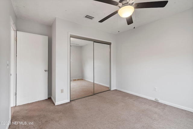 unfurnished bedroom featuring light colored carpet, ceiling fan, and a closet