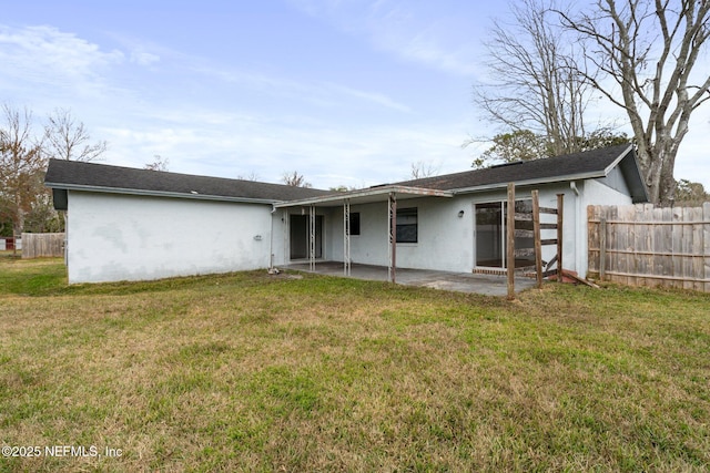 rear view of house with a lawn and a patio area