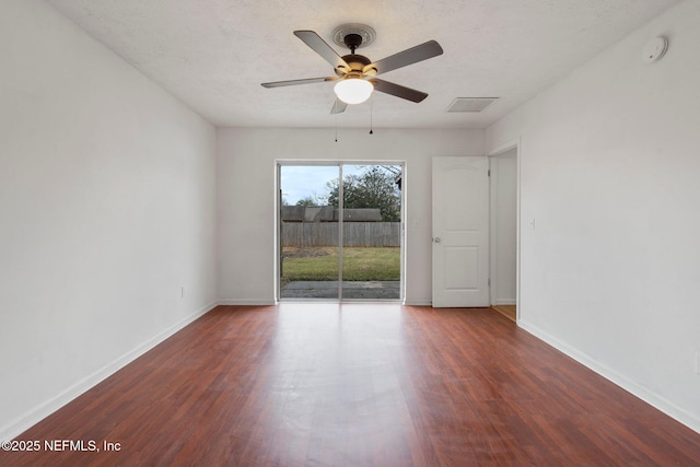 spare room with dark wood-type flooring and ceiling fan