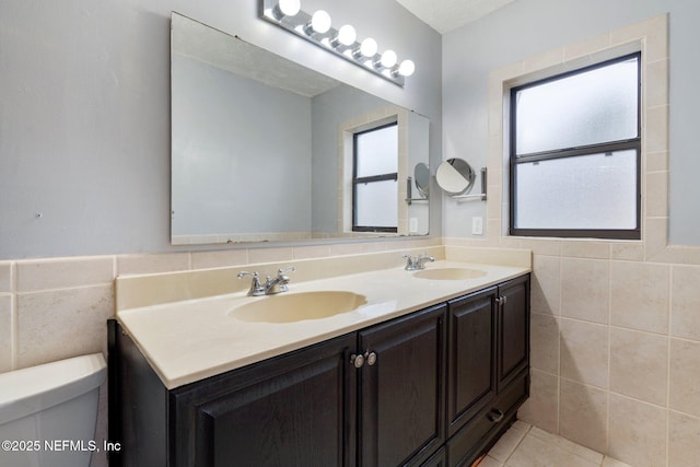 bathroom with tile walls, tile patterned floors, vanity, and toilet