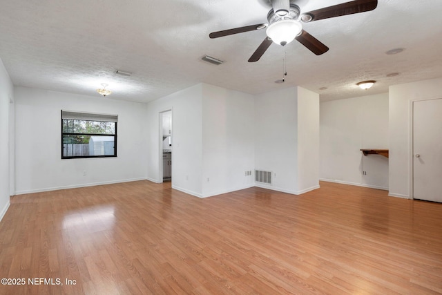 spare room featuring a textured ceiling, ceiling fan, and light hardwood / wood-style flooring