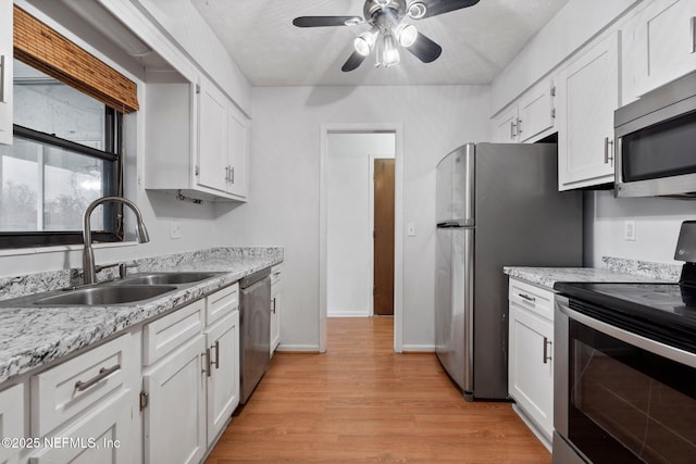 kitchen featuring sink, stainless steel appliances, white cabinets, and ceiling fan