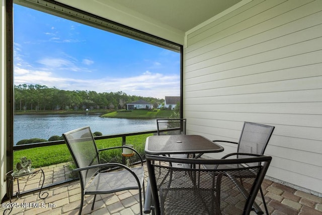 sunroom featuring a water view