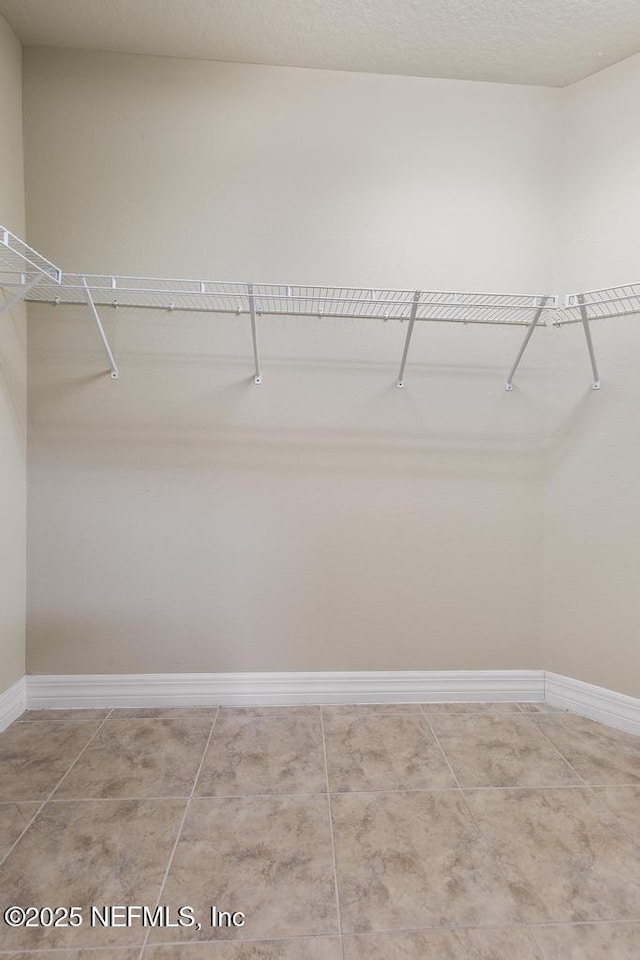 walk in closet with tile patterned floors