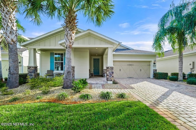 view of front facade with a porch, a garage, and a front lawn