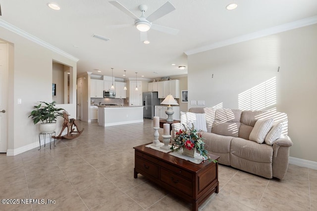 living room featuring ceiling fan, sink, light tile patterned floors, and crown molding