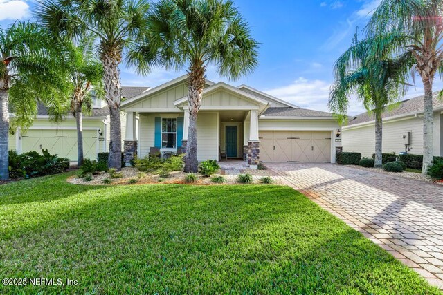 view of front of house with covered porch, a garage, and a front yard