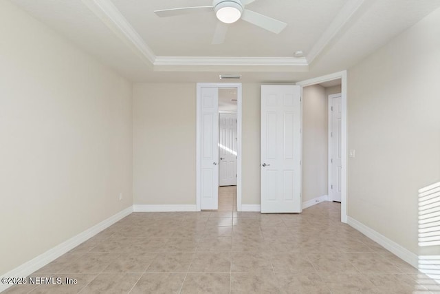 unfurnished bedroom featuring a raised ceiling, ceiling fan, ornamental molding, and light tile patterned flooring