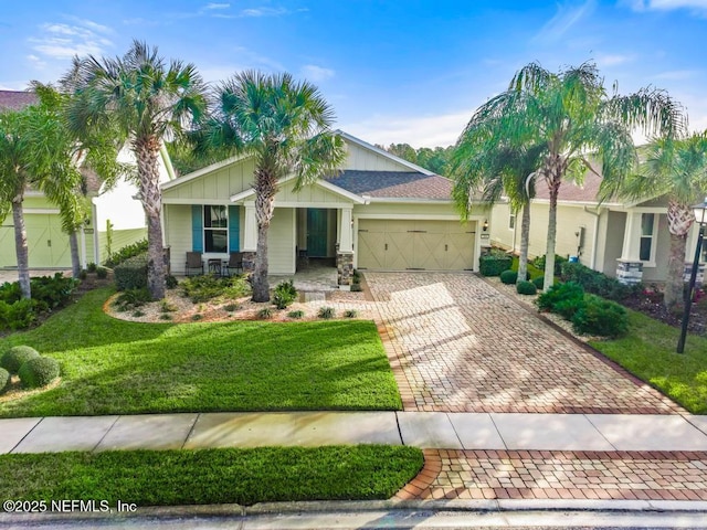 view of front facade with a front yard, a garage, and covered porch