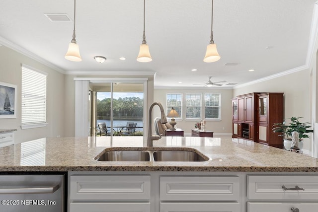 kitchen with light stone countertops, ornamental molding, sink, pendant lighting, and white cabinetry