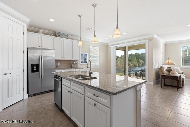 kitchen with sink, stainless steel appliances, an island with sink, white cabinets, and ornamental molding